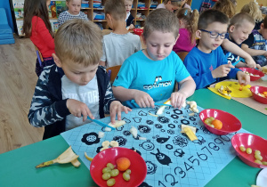 Igor,Kuba,Marcel i antek kroją owoce na sałatkę